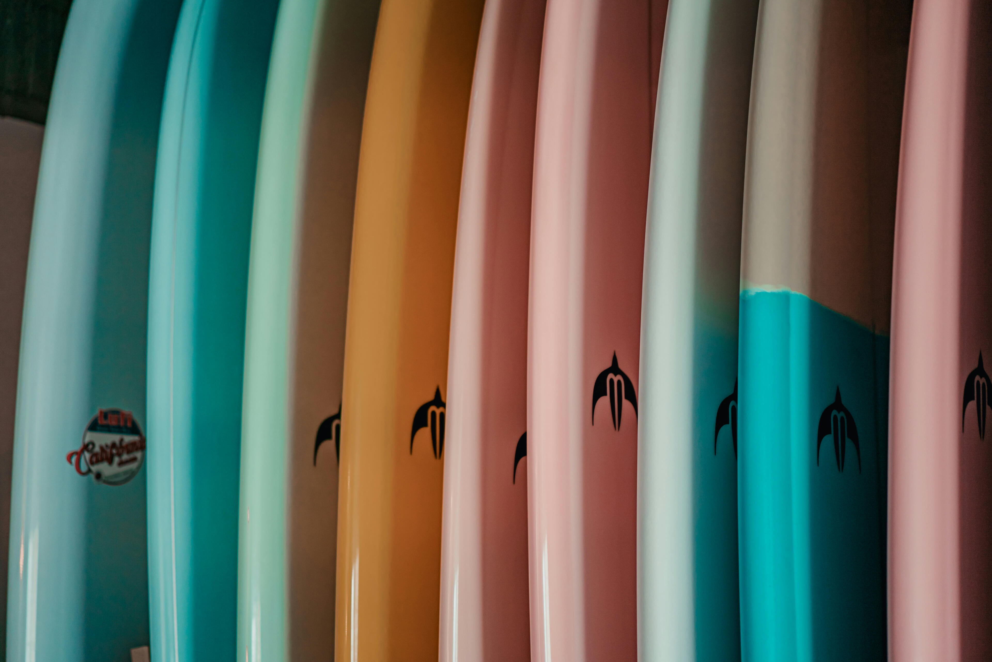 colorful surfboards lined up on rack